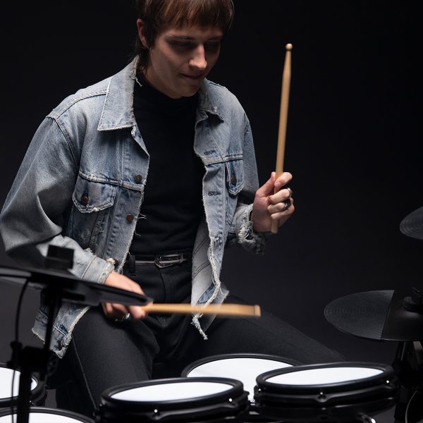 drummer playing Titan 50 electronic drum kit in empty dark room