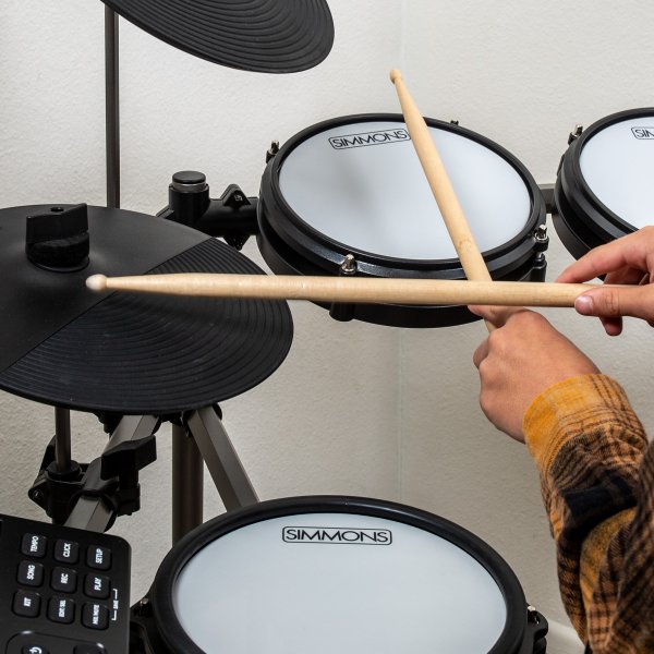 hands with drumsticks playing tom and hi-hats on Simmons Titan 20 drum kit