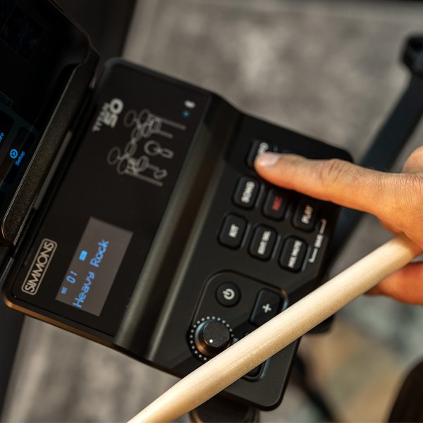 player pressing panel on Titan 50 while holding drum stick